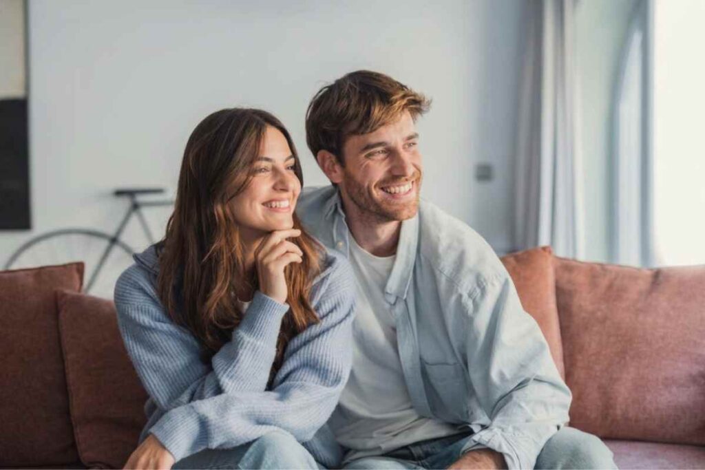 Glimlachend koppel dat samen relaxt op de bank thuis
